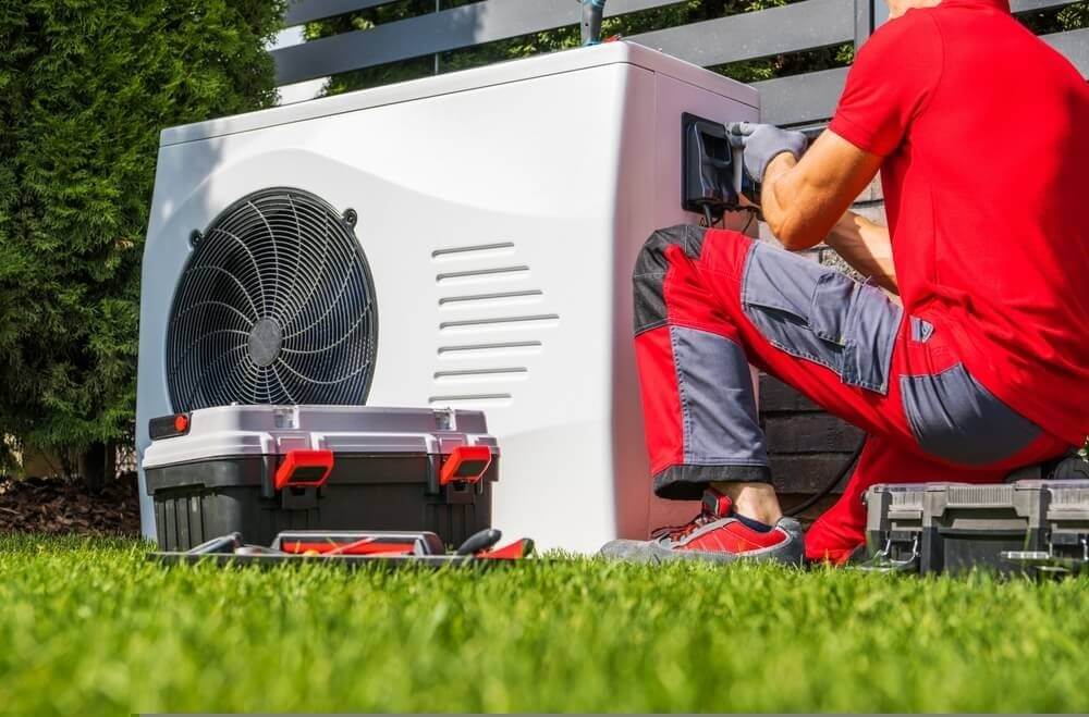 A man in a red shirt fixing pool heat pumps in Brisbane