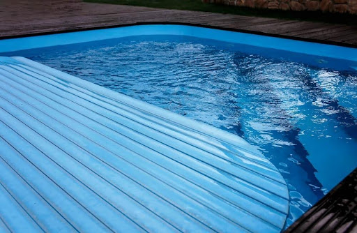 swimming pool cover half covering a underground pool